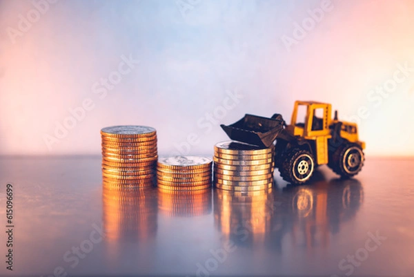 Fototapeta Closeup stack coins with forklift vehicle using as business and logistics industry concept