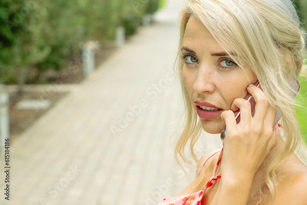 Fototapeta PRETTY GIRL SMILING WHILE IS TAKING A SELFIE AND CALLING BY PHONE IN THE STREET