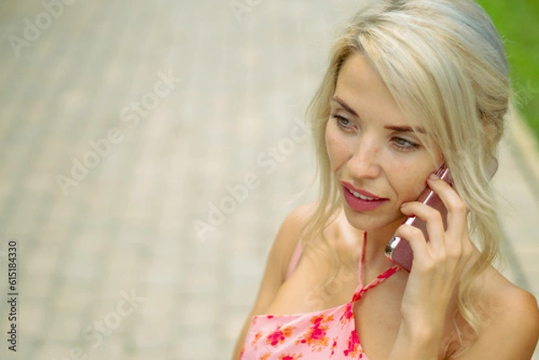 Fototapeta PRETTY GIRL SMILING WHILE IS TAKING A SELFIE AND CALLING BY PHONE IN THE STREET