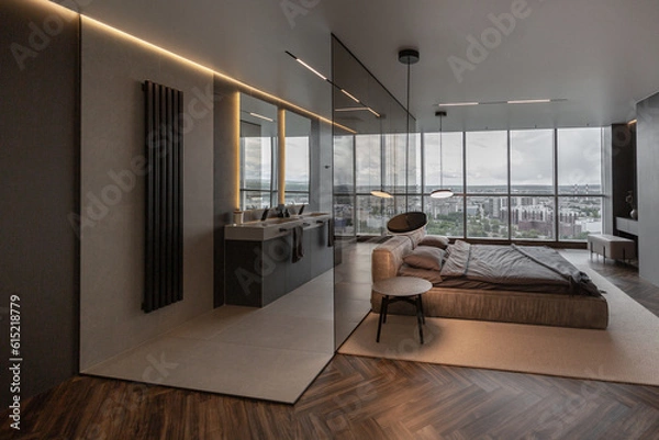 Obraz cool expensive interior design of room in prestigious luxury hotel with dark tones with modern LED lighting and stylish furniture. the area with a sink is separated by dark glass from the bedroom