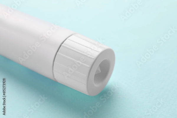 Fototapeta Tube of ointment on light blue background, closeup. Space for text