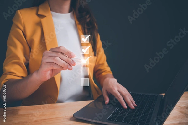Obraz Businesswoman using laptop online checklist survey, filling out digital form checklist, take an assessment, questionnaire, evaluation, online survey, online exam, Business performance checklist.