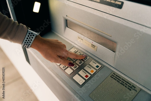 Obraz girl presses the buttons at the ATM