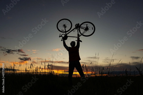 Obraz cyclist silhoutte with bicycle raised to sky race and victory concept on the background of a beautiful sunset