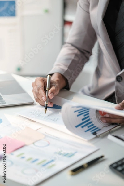 Fototapeta Close up young man with calculator counting making notes at home, hand is writing in a notebook. Savings finances concept