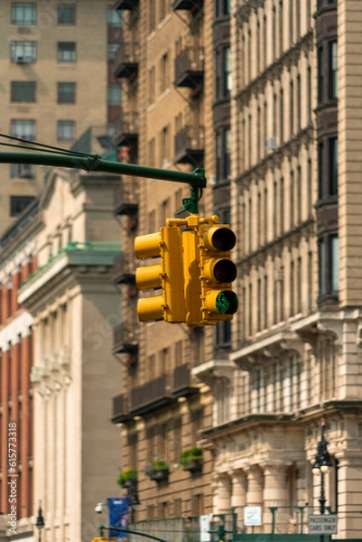 Fototapeta Traffic light signal in the city. American style yellow traffic light in New York City. Traffic in the city. Background with classical buildings.