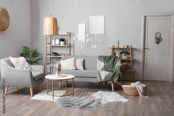 Fototapeta Interior of modern living room with sofa, armchair and dream catcher hanging on door and from ceiling