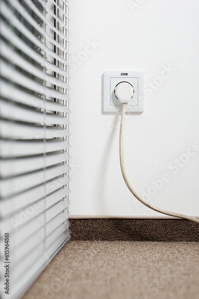 Fototapeta socket in the plug with a plug with a wire on a white wall