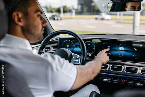 Fototapeta a man in an expensive SUV uses a car multimedia with a touchscreen