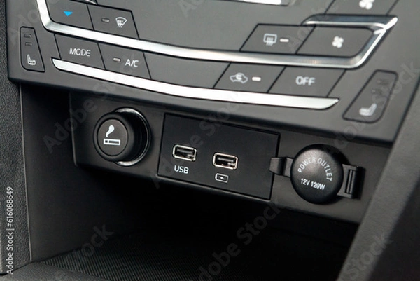 Fototapeta The central control console on the panel inside the budget car close-up with climate control and audio system