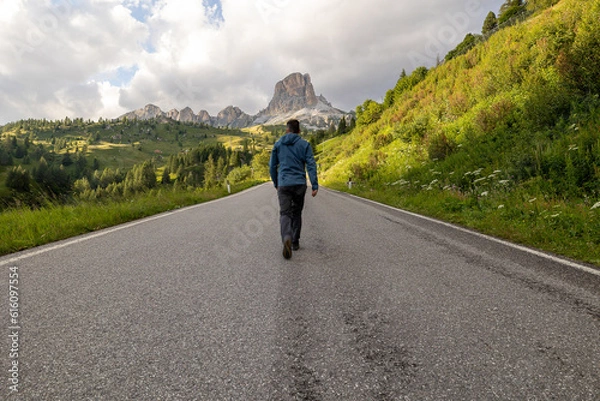 Obraz man walking in the road to the mountains