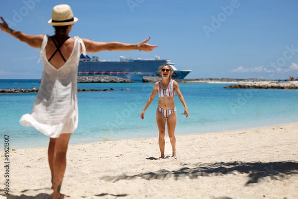 Obraz Mother and Daughter Embrace Happiness on Island Paradise with a Cruise Ship in the background