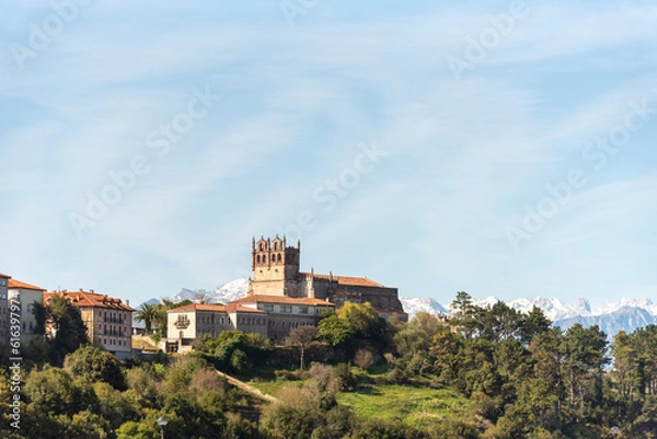 Fototapeta Panoramic view of the medieval castle of the tourist village of San Vicente de la Barquera in Cantabria surrounded by an impressive natural landscape with the snow-capped Picos de Europa 
