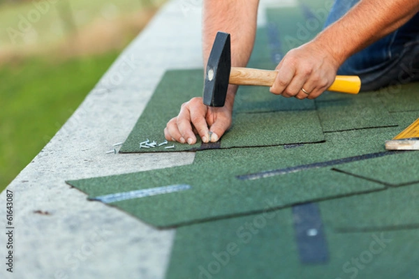Obraz Worker hands installing bitumen roof shingles