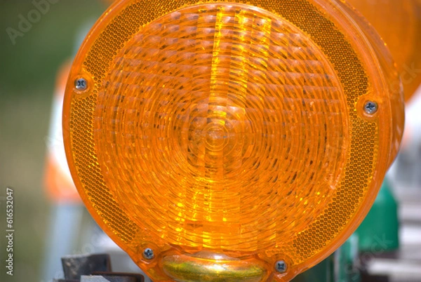 Obraz The orange lens of a construction barricade light.