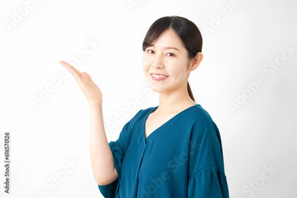 Fototapeta 左側を手のひらで指すミドルエイジ女性　白背景