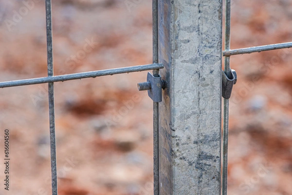 Fototapeta Nut and bolt connected mesh fence with column, Mesh fence of railway, selective focus.