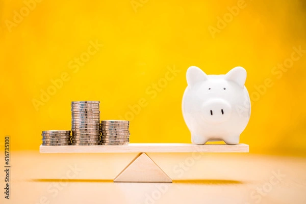 Obraz Piggy bank and gold coin with recommend an investment goal of the victory for ones success and home put on the scales on the yellow background in the office, Loan for investment in the future concept.