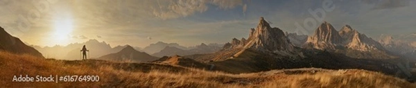 Fototapeta Great panorama of the Giau Pass with mountain Ra Gusela and a tourist at sunset. 