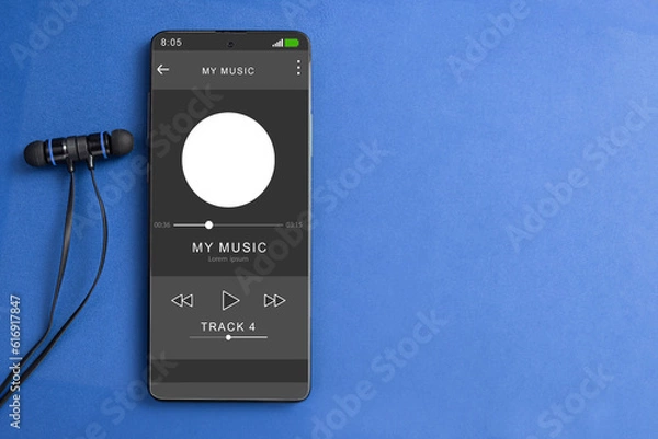 Fototapeta Wired headphones and a phone on the table