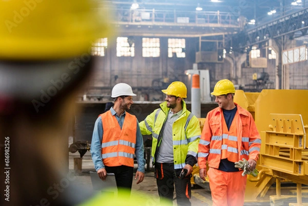 Obraz Steel workers walking and talking in factory