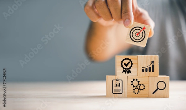 Obraz Wood block stacking by hand, showcasing the essence of business strategy and Action plan. Copy space for professional use, emphasizing the concept of growth.