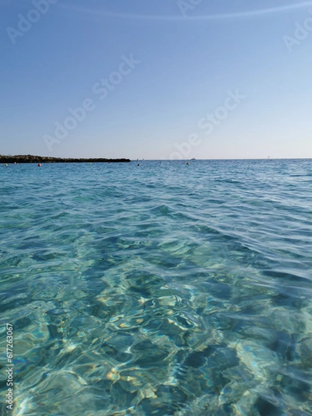Obraz Fig Tree Bay beach, crystal clear water, white sand at the bottom, small island off the coast.