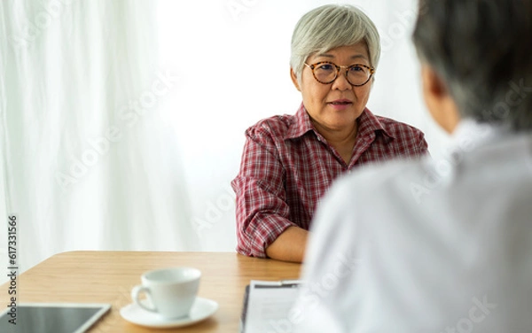Fototapeta Asian senior doctor wearing uniform with stethoscope help discussing and consulting talk to sick senior patient checkup information, support, care, diseases, treatment in hospital.elderly healthcare