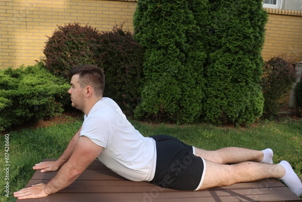 Obraz European man does lower back exercises for spine 
