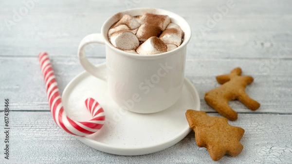 Fototapeta Hot chocolate with marshmallows in a white cup on a wooden surface.