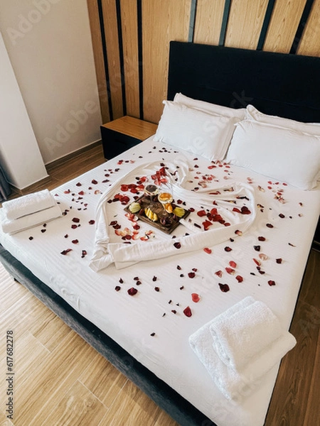 Fototapeta Honeymoon suite with heart and rose petals