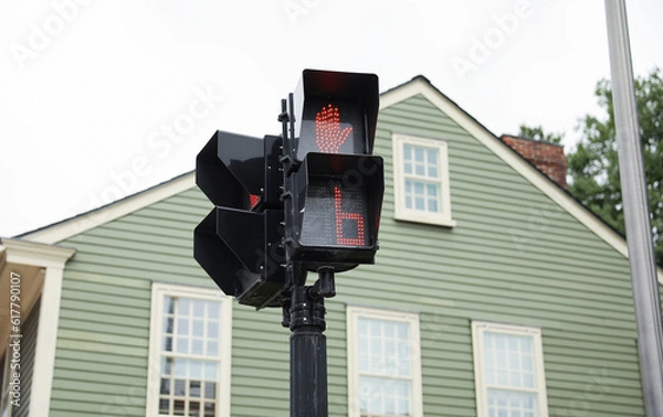 Fototapeta street light with traffic signals, displaying the colors red, green, and yellow. The walking sign indicates pedestrian safety and the flow of urban life