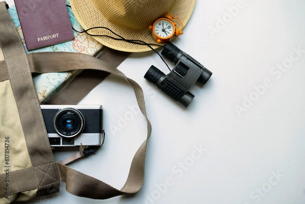 Fototapeta Top view of accessories for tourist to travel in Brown tone on Travel concept, Camera on notebook and airplane with passport and watch and hat with wallet  on wooden background.