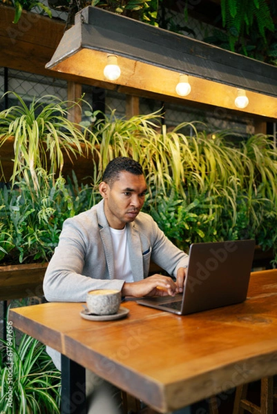 Obraz Man working on laptop at cafeteria
