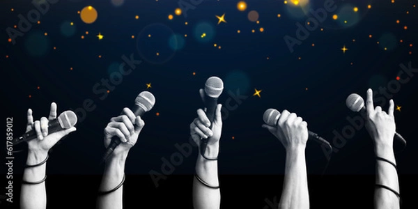 Obraz microphone in hands on twinkling stars background. singing contest concept