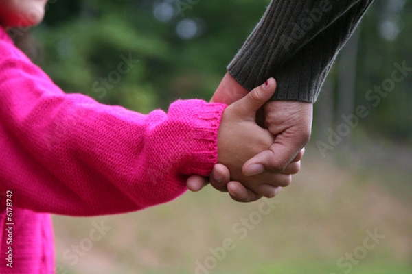 Obraz A mixed race mother and daughter holding hands