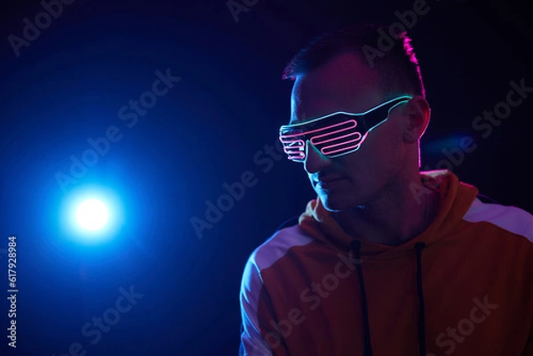 Fototapeta guy in neon cyber glasses on a dark background, cyber space concept