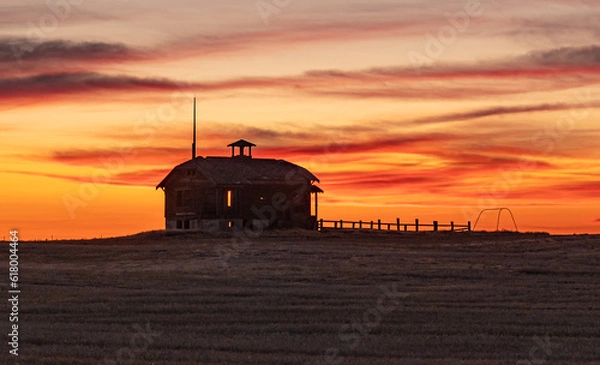 Fototapeta Old Abandoned Schoolhouse, with corral and swing silhouetted  in the setting sun. Wasco County, Oregon