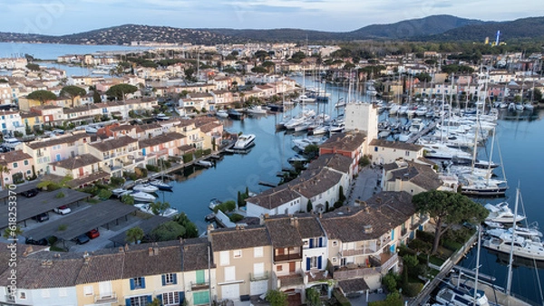 Fototapeta Port Grimaud harbor in France in springtime with yachts and sailboats and Mediterranean Sea in the evening, drone shot, Cote d'Azur