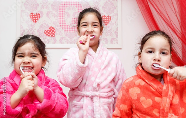 Obraz Three young children brushing their teeth