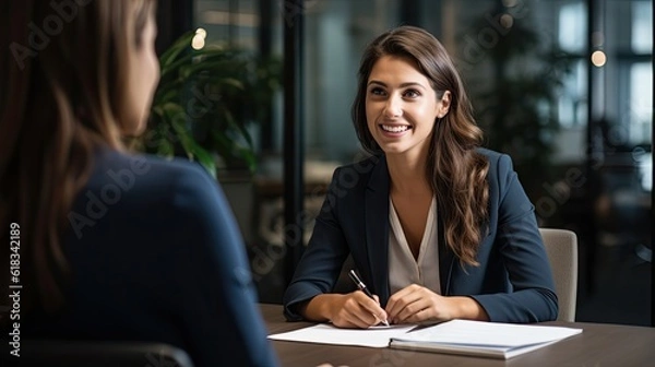 Fototapeta Smiling Female Manager Interviewing an Applicant In Office