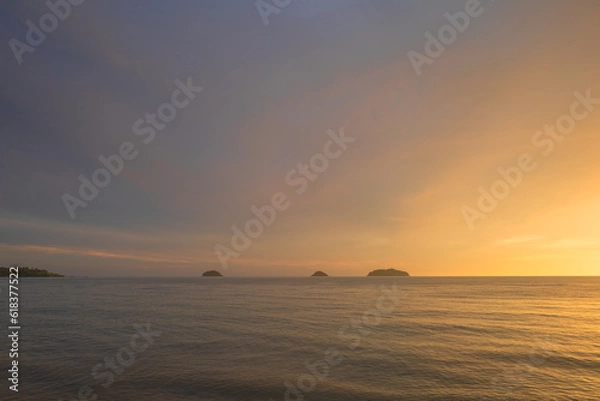 Fototapeta sea at sunset. Dramatic sky with glowing golden pink clouds, reflections in the water. Setting sun.Abstract natural pattern, texture, background, concept image