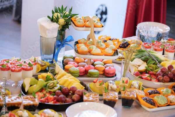Obraz candy bar dessert table with various macarons, sweets, cupcakes, fruits and pies.