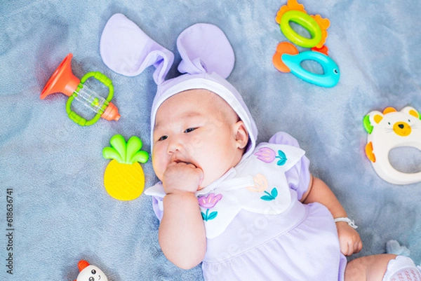 Fototapeta baby boy in bunny costume,Cute baby Easter bunny. Little baby boy with bunny ears and Easter eggs in wicker basket in white fur. Symbol of Easter holiday, birth, spring, religion.
