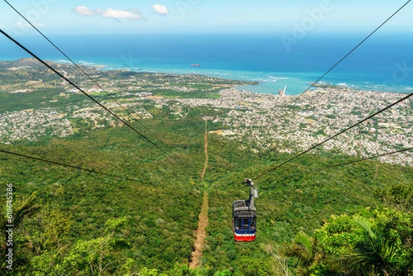 Fototapeta View of Puerto Plata, forest, ocean, and the cable car from the top of Mount Isabel de Torres - cable car has partly descended