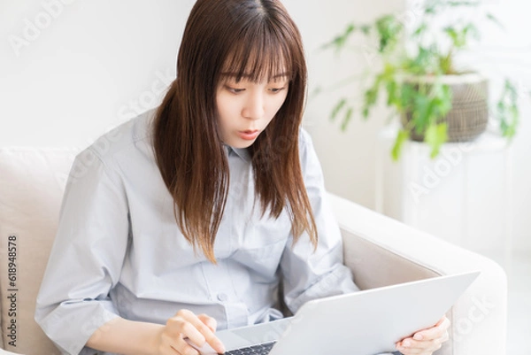 Fototapeta 部屋でラップトップコンピューターを見る女性