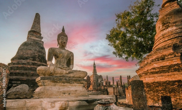 Obraz Sunset  over Sitting Buddha and Wat Mahathat temple in Sukhothai historical park.
