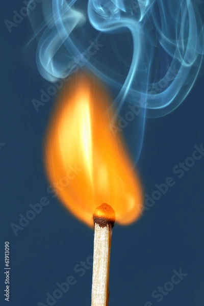 Fototapeta Lighted match on a blue background.