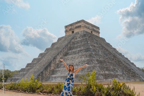 Obraz young woman visits one of the most beautiful pyramids in the world, the pyramid of chichen itza in mexico with her camera