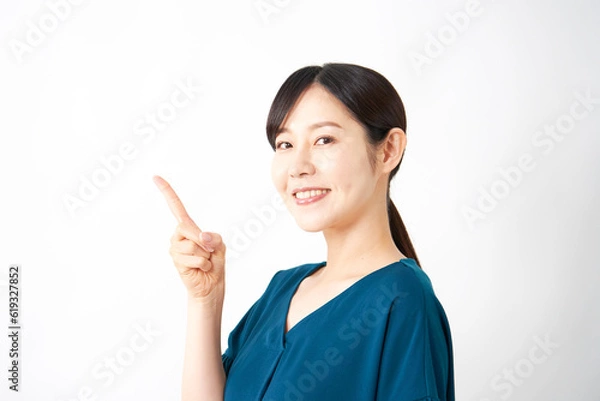 Fototapeta 左側を指差すミドルエイジ女性　白背景